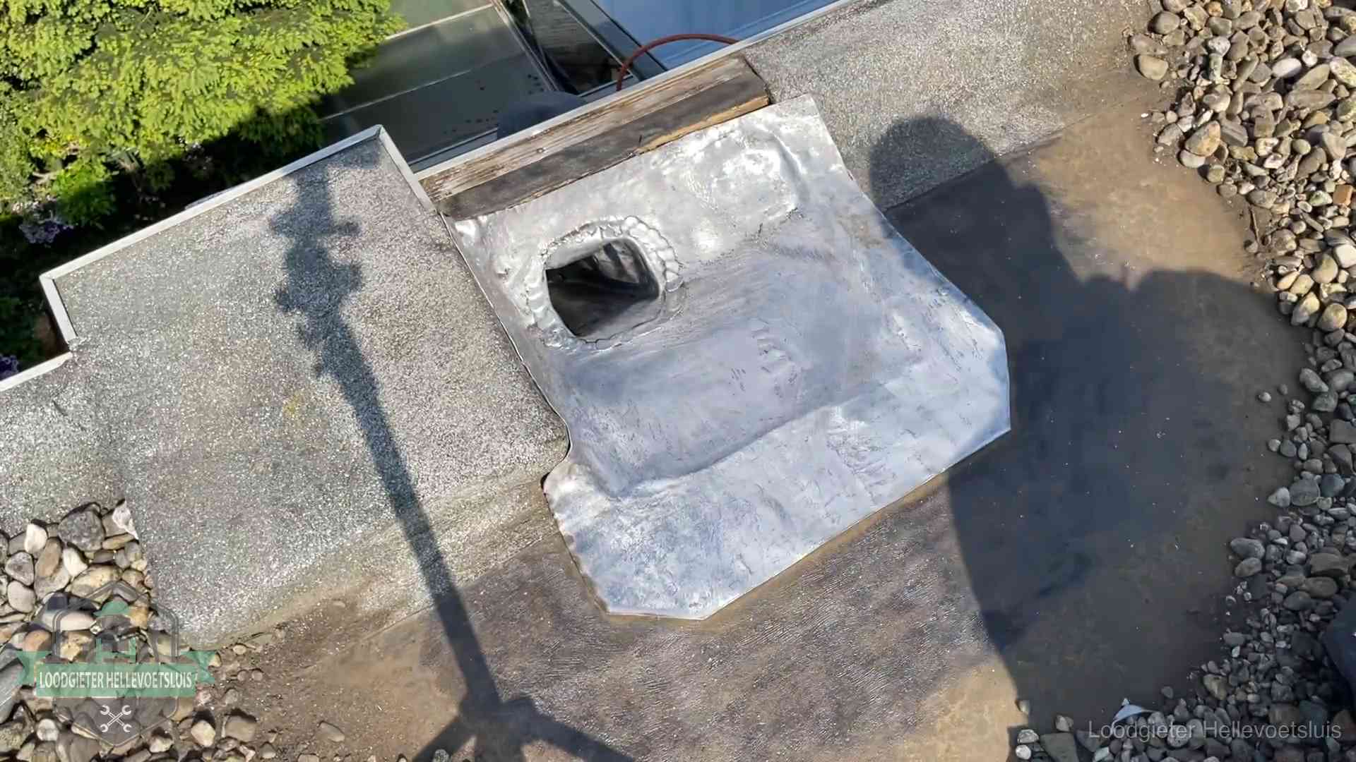 Noodafdichting bij daklekkage in Hellevoetsluis Vers afgedichte dakdoorvoer met lood en zink op een plat dak in Hellevoetsluis