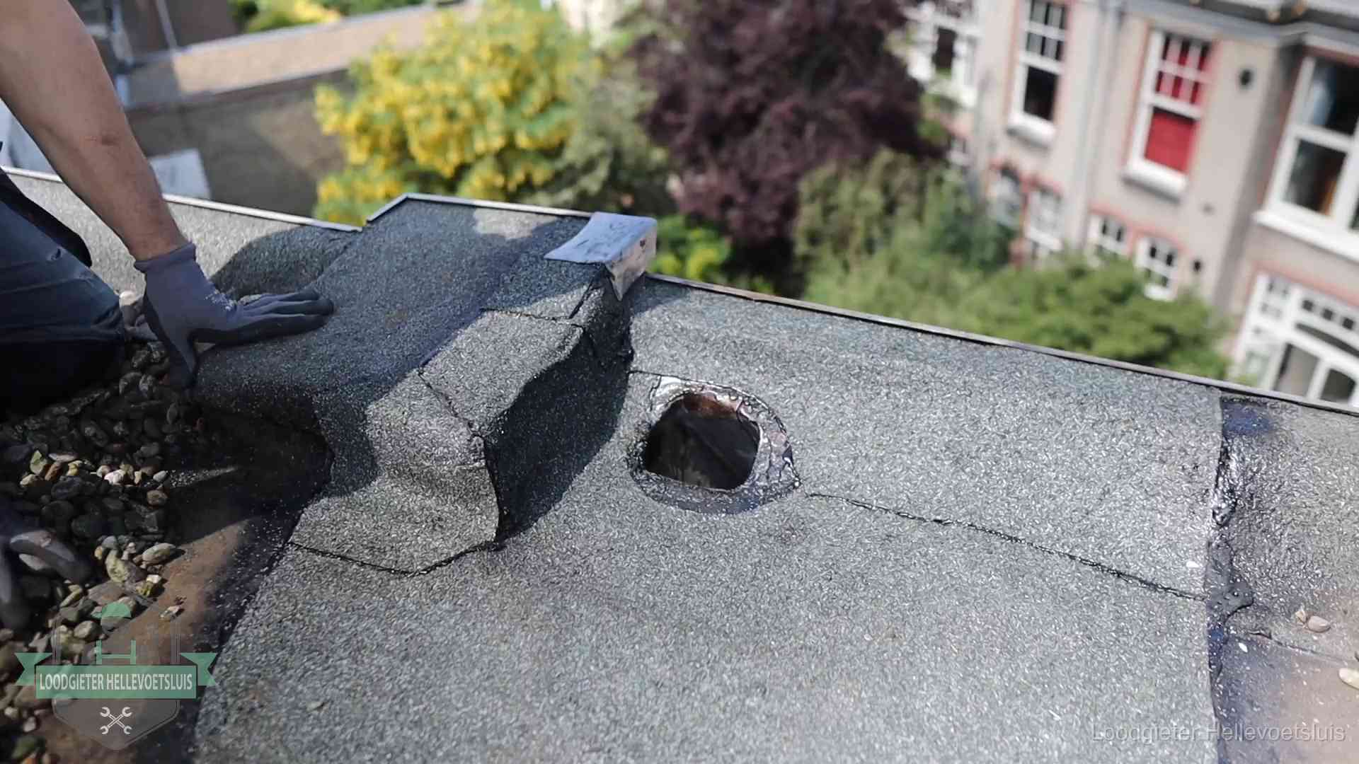 Daklekkage-inspectie op een plat dak in Hellevoetsluis Loodgieter inspecteert een beschadigd bitumen plat dak tijdens een daklekkage-inspectie in Hellevoetsluis
