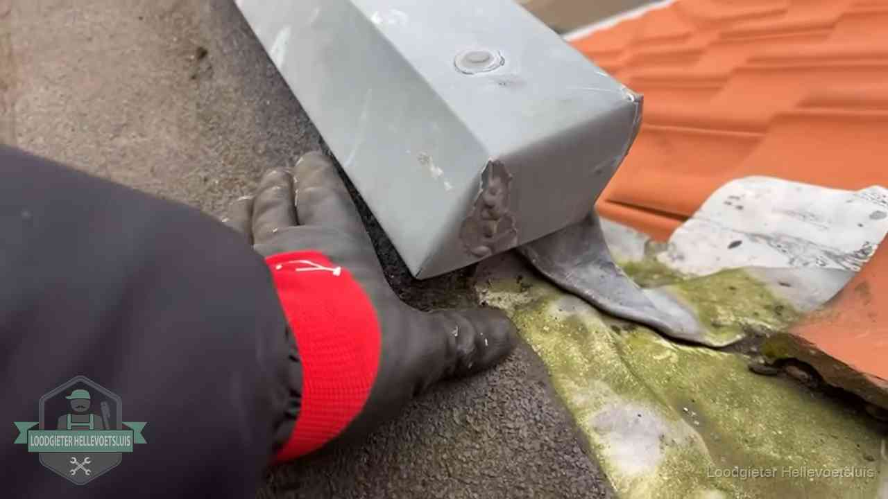 Hemelwaterafvoer en dakgoot controleren in Hellevoetsluis Controle van een zinken hemelwaterafvoer met loodslab bij dakpannen in Hellevoetsluis