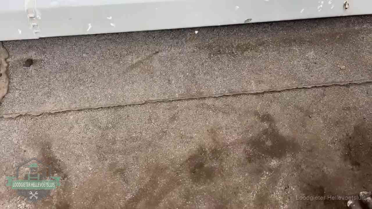 Stormschade en neerslag op daken in Hellevoetsluis Vochtplekken bij de naad van een plat dak na aanhoudende regen in Hellevoetsluis