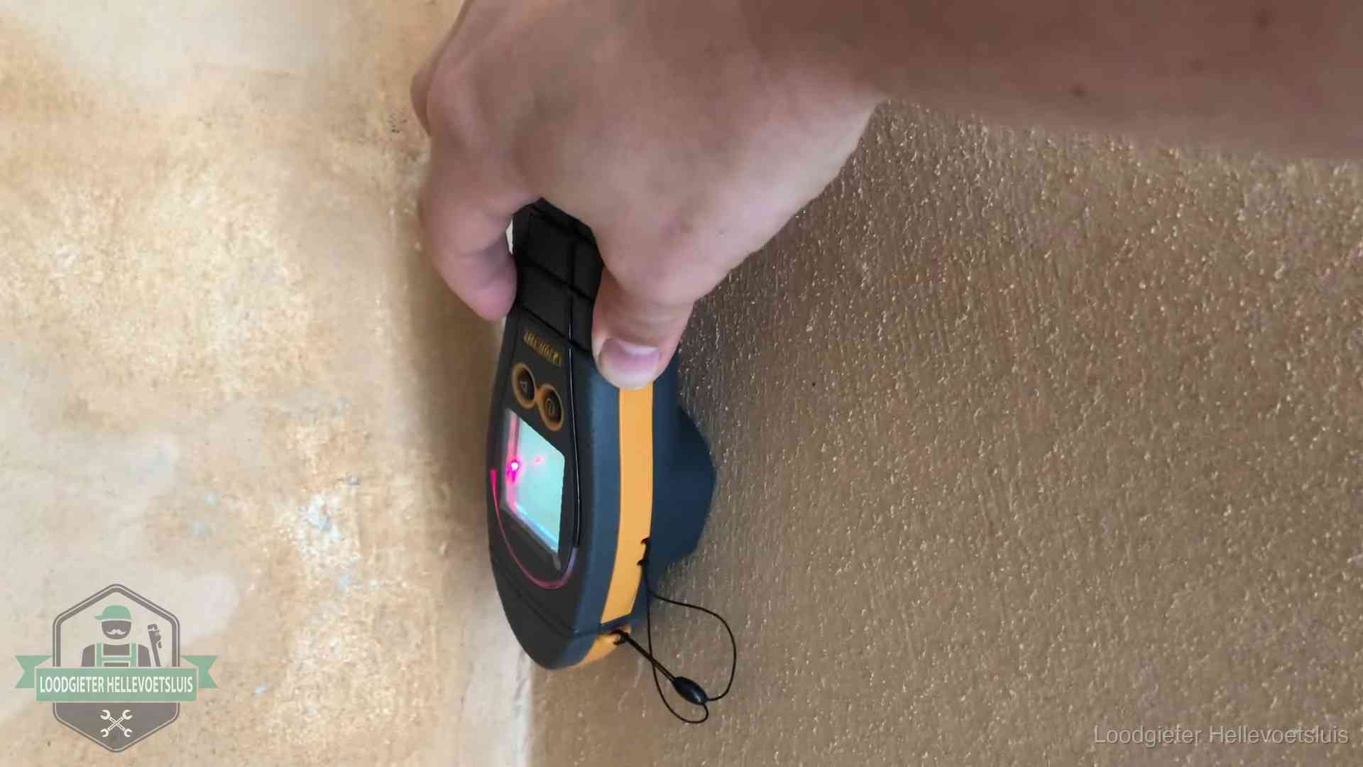 Daklekkage opsporen zonder hakwerk in Hellevoetsluis Vochtmeter tegen een muur met vochtplekken tijdens het opsporen van een daklekkage in Hellevoetsluis