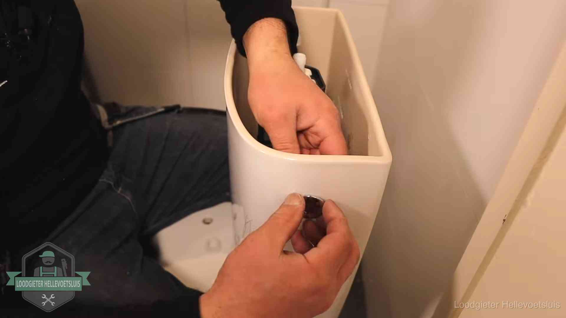 Je wc verstoppingsvrij houden in Hellevoetsluis Drukknop van een duoblok-stortbak wordt gemonteerd bij een toilet in Hellevoetsluis